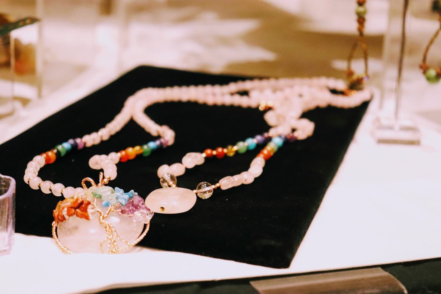 A beaded necklace with a painted teacup pendant