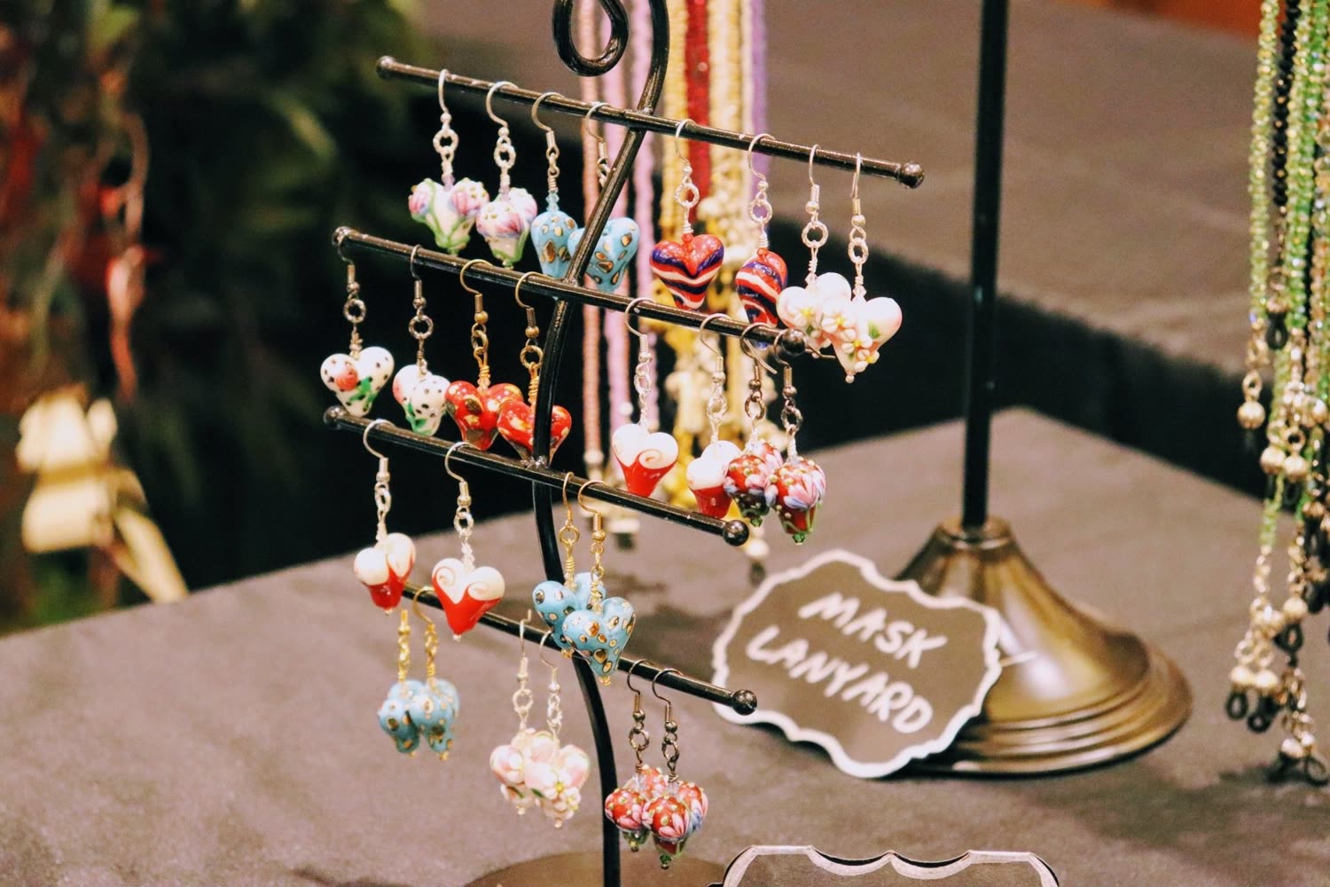 Handmade earrings hanging on a display stand
